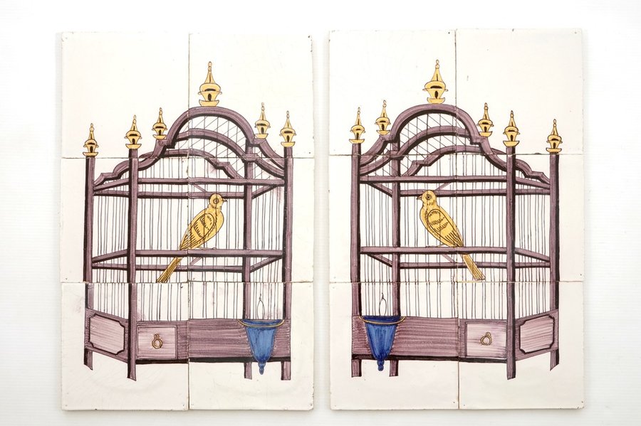 A pair of polychrome Dutch Delft tile panels with canaries in a cage, 18/19th C.