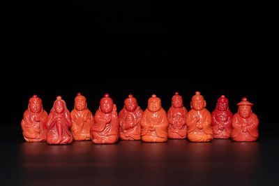 A set of ten Chinese coral-red glass Luohan-form snuff bottles, 20th C.