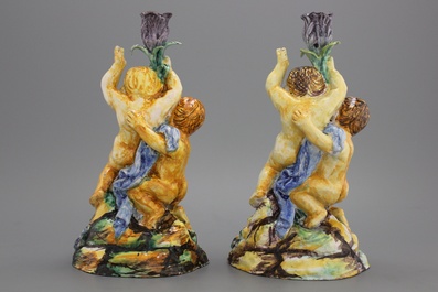 A pair of Spanish Talavera candlesticks with putti on a branch, 18th C.