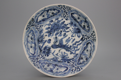 A Chinese late Ming Dynasty Swatow blue and white plate with a phoenix bird, 16th C.
