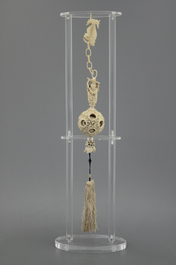 A Chinese ivory hanging puzzle ball on plexi stand, 19th C.