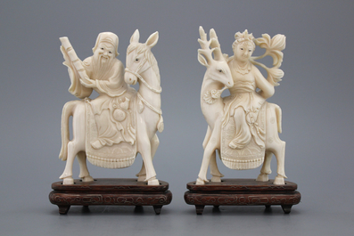 A pair of Chinese carved ivory figures on a wooden base, early 20th C.