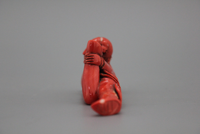 A carved Chinese red coral snuff bottle as a reclining lady, 18/19th C.