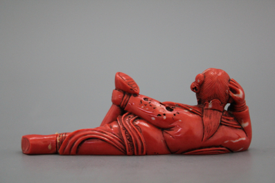 A carved Chinese red coral snuff bottle as a reclining lady, 18/19th C.