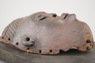 An African carved wood Chokwe mask, mounted on wood, early to mid 20th C.