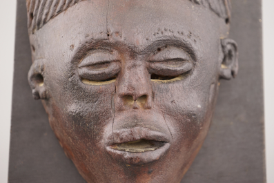 An African carved wood Chokwe mask, mounted on wood, early to mid 20th C.