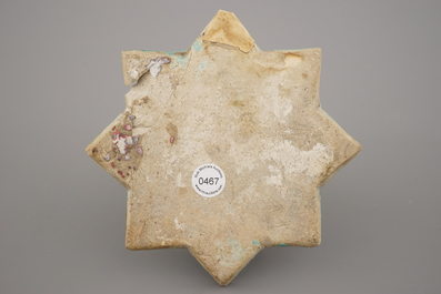 A turquoise ground Lajvardina cold painted star-shaped tile, 14th C.