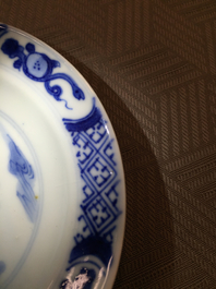 A Chinese porcelain blue and white cup and saucer with a &quot;Rotterdam Riot&quot; decor, Kangxi