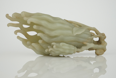 A jade buddha hand on a carved wood stand, Qing dynasty, 18th C.