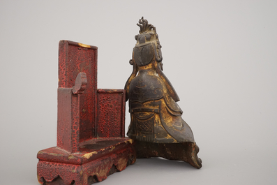 A partly gilt bronze model of a Guanyin, seated on a lacquered wood throne, Ming dynasty