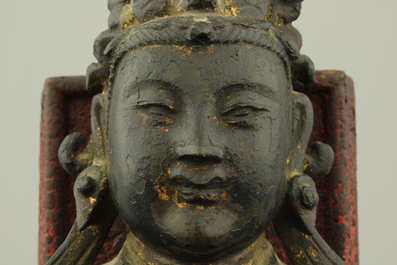 A partly gilt bronze model of a Guanyin, seated on a lacquered wood throne, Ming dynasty