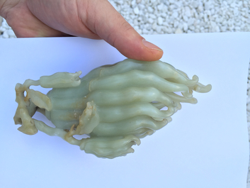 A jade buddha hand on a carved wood stand, Qing dynasty, 18th C.