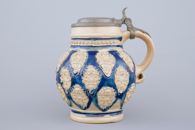 A globular Westerwald stoneware jug with applied masks, 17th C.