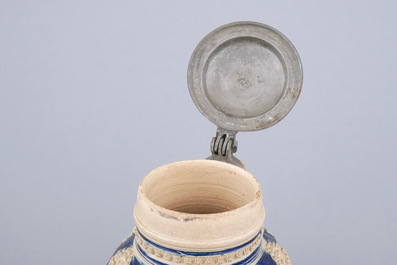 A globular Westerwald stoneware jug with applied masks, 17th C.