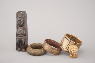 A selection of African bronze bracelets, a crucifix and carved wood figure, 19/20th C.