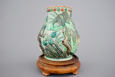 A Nanking famille verte relief-decorated hu-shaped landscape vase, 19th C.