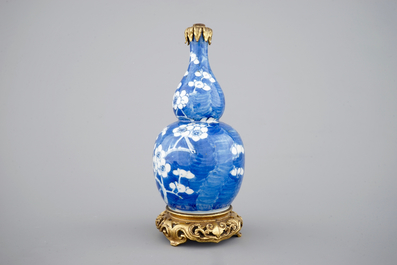 Een blauw-witte kalebasvormige vaas met blauwe fondkleur en chinoiserie montuur, 18/19&egrave;me
