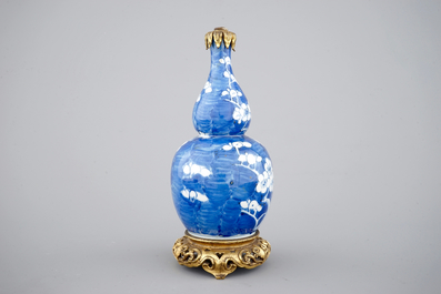 Een blauw-witte kalebasvormige vaas met blauwe fondkleur en chinoiserie montuur, 18/19&egrave;me