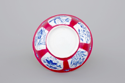 An unusual Chinese ruby ground and overglaze blue cup and saucer, Yongzheng, 1722-1735