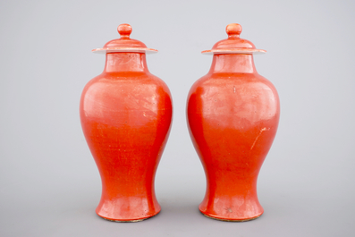 A pair of Chinese monochrome coral ground baluster vases with cover, 19th C.