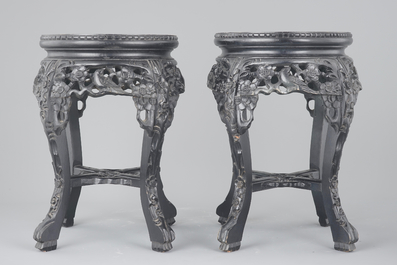 A pair of Chinese carved darkened wood vase stands with marble top, 20th C.