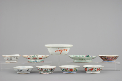 A Chinese famille rose basin with a bird on a branch and 8 smaller bowls, 19th C.