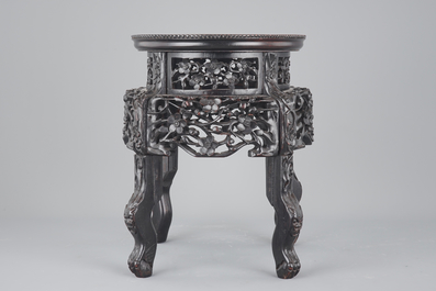 An elaborately carved Chinese hardwood vase stand with dreamstone insert, 19th C.