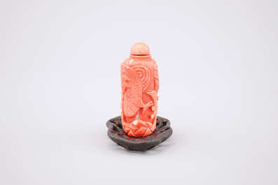 A Chinese carved red coral dragon snuff bottle on stand, 19th C.