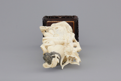 A finely carved Chinese ivory lady on wooden stand, ca. 1900