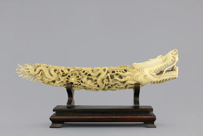 A Chinese ivory carving of a dragon on wooden stand, early 20th C.