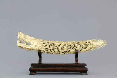 A Chinese ivory carving of a dragon on wooden stand, early 20th C.