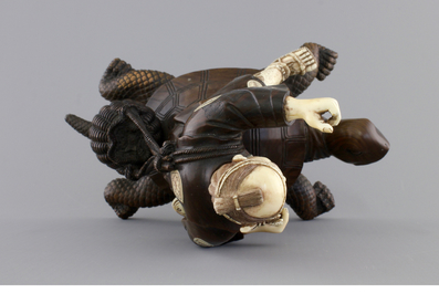 A signed Japanese carved ivory and wood figure of an immortal seated on a turtle, 19th C.