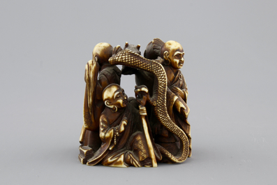 A Japanese patinated ivory netsuke: a dragon amongst sages, 19th C.