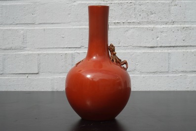 Un vase en porcelaine de Chine au fond rouge de corail, orn&eacute; d'un dragon, 19&egrave;me