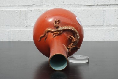 Un vase en porcelaine de Chine au fond rouge de corail, orn&eacute; d'un dragon, 19&egrave;me