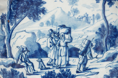 Een fijn Delfts blauw-wit geschubd bord met reizigers in een landschap, 18e eeuw