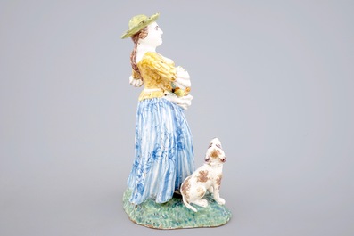 A tall polychrome pottery group of a lady with a dog, Nevers, 18th C.