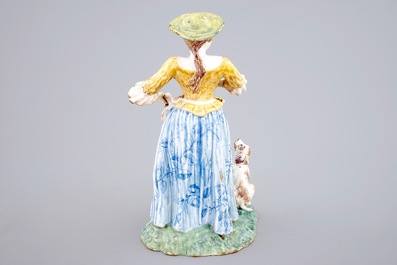 A tall polychrome pottery group of a lady with a dog, Nevers, 18th C.