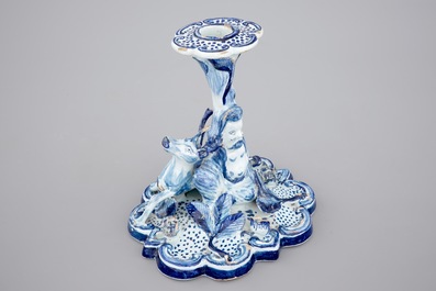 A blue and white Dutch Delft candlestick with a deer and a buddhist, 18th C.