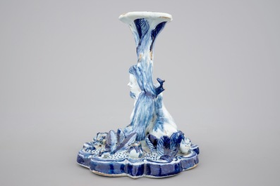 A blue and white Dutch Delft candlestick with a deer and a buddhist, 18th C.