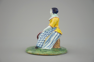 A polychrome Dutch Delft figure of a lady selling fish, 18th C.