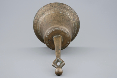 A tall bronze table bell with stylised handle, 16/17th C.