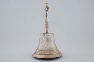 A tall bronze table bell with stylised handle, 16/17th C.