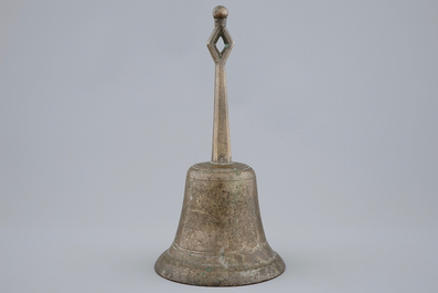 A tall bronze table bell with stylised handle, 16/17th C.