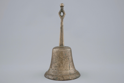 A tall bronze table bell with stylised handle, 16/17th C.