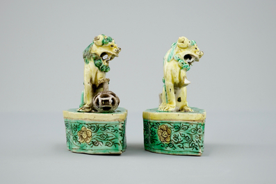 A pair of Chinese verte on biscuit foo dog joss stick holders, Kangxi