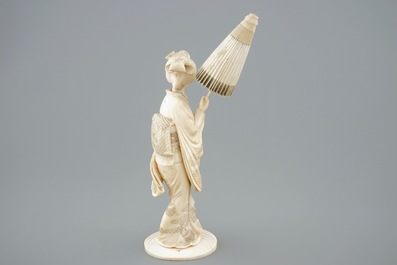 Een Japanse ivoren okimono, dame met parasol, 19e eeuw