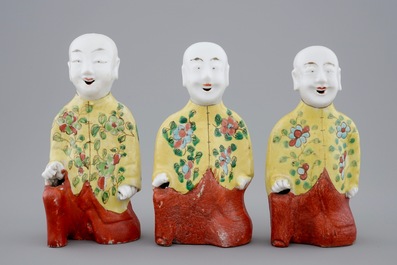 Een set van drie Chinese porseleinen geknielde jongens, 19e eeuw