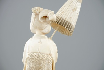 A Japanese carved ivory okimono of a lady holding a parasol, 19th C.