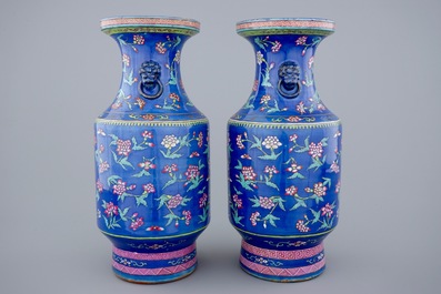 A pair of Chinese blue ground famille rose vases with flowers, 19th C.